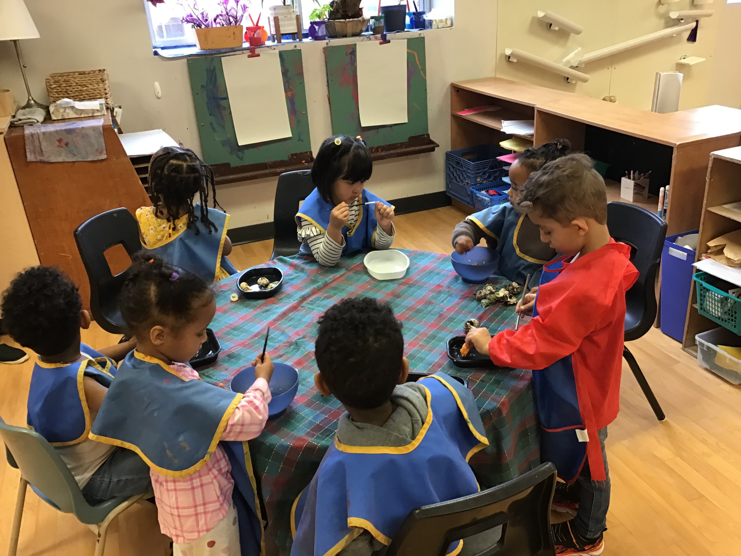 Children seated at a table playing together Children seated at a table playing together