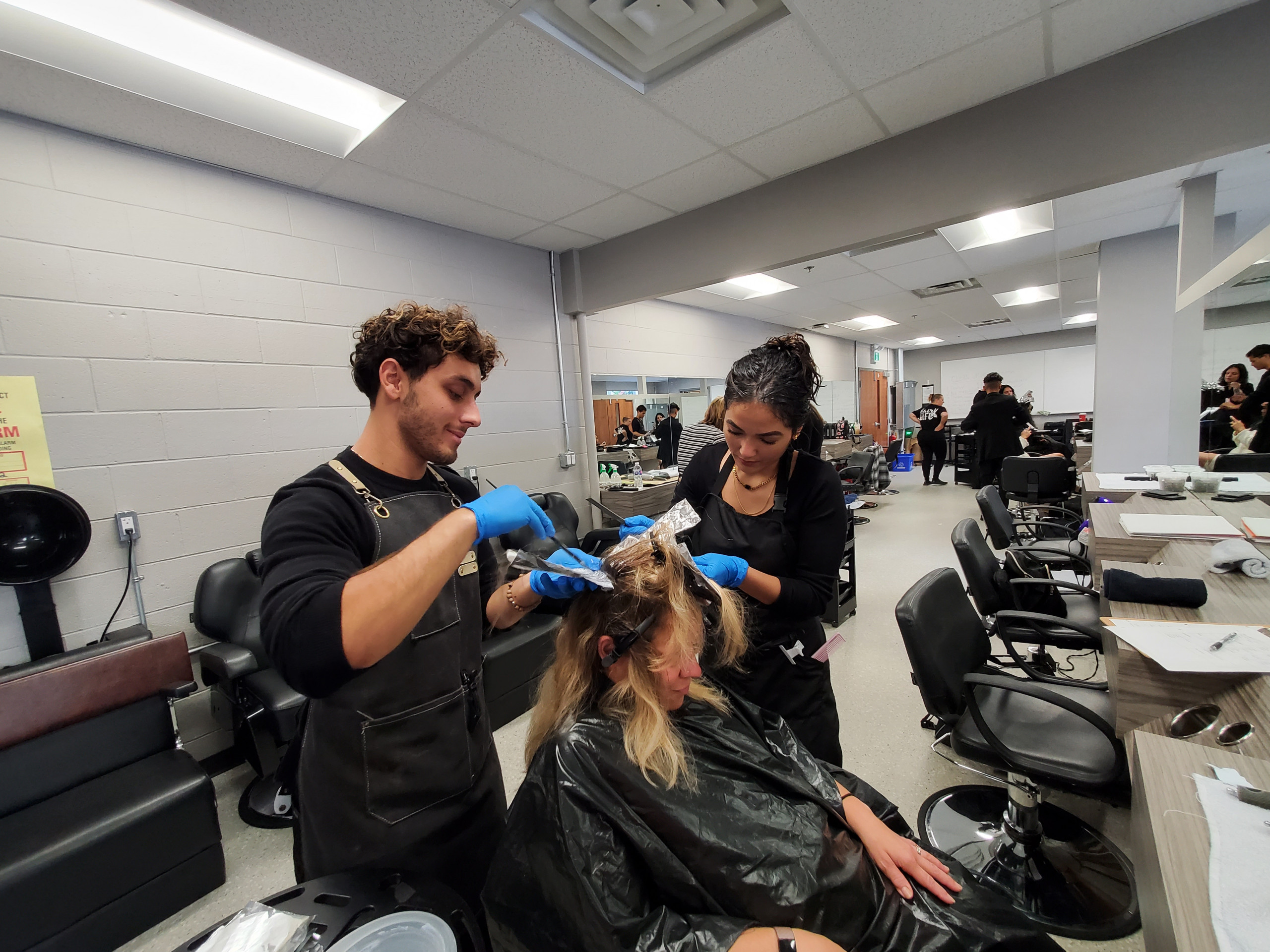Three Students Practicing Hairstyling Three Students Practicing Hairstyling